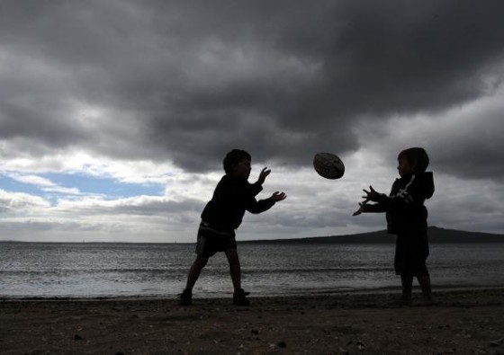 This photo taken on September 3, 2011 shows children playing rugby at Narrow Neck Beach in Devonport near Auckland less than a week before the kickoff of the 2011 Rugby World Cup. The World Cup will be played in New Zealand from September 9 to October 23.  TOPSHOTS  AFP PHOTO / FRANCK FIFE